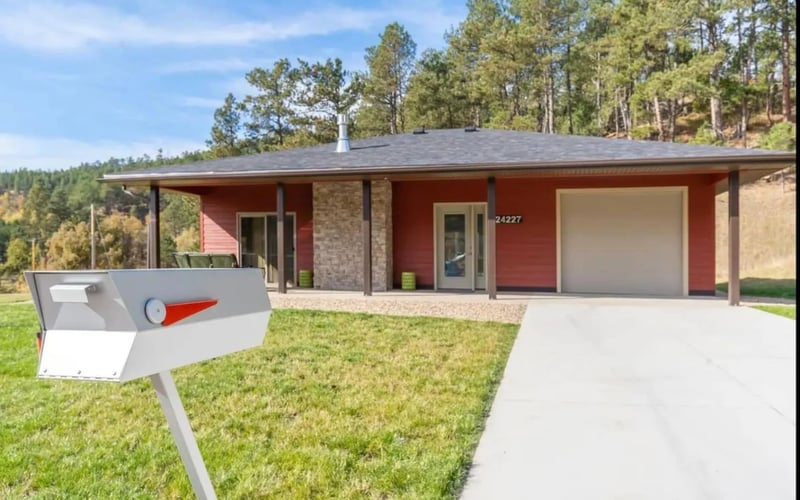 Granite Point, red exterior with pine hillside, Keystone SD